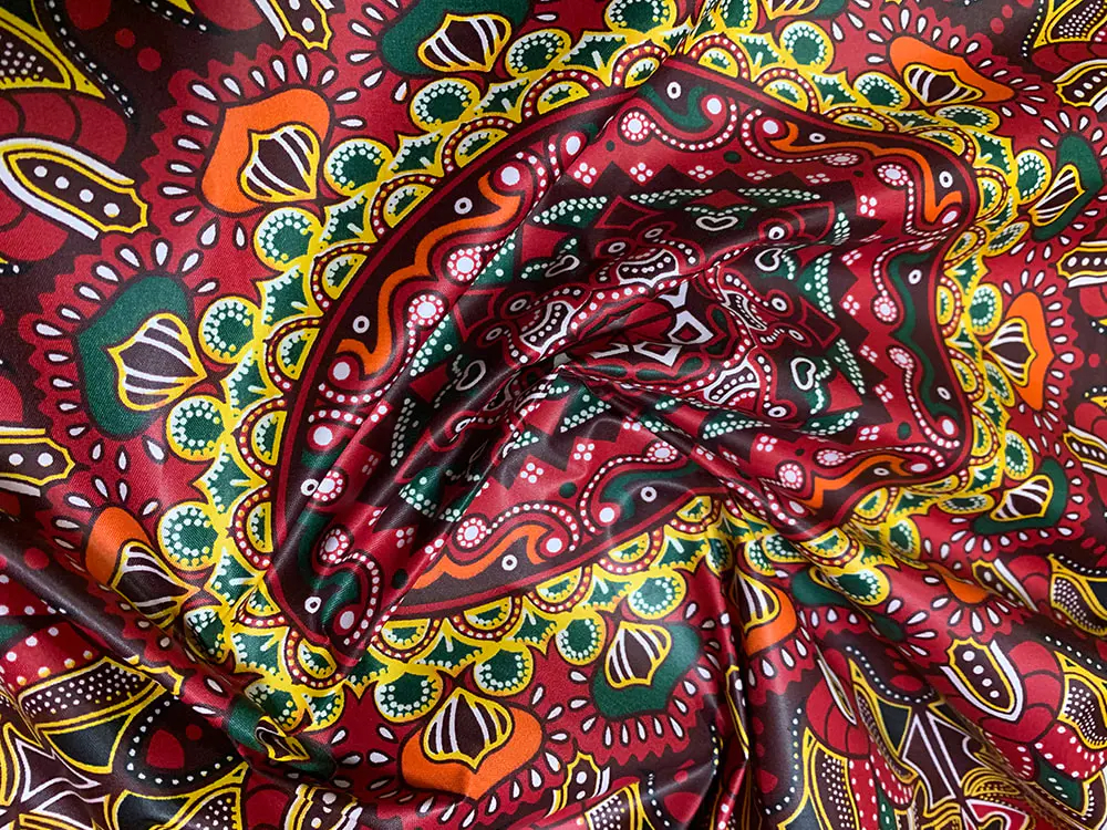 Was sind die einzigartigen Merkmale von afrikanischem Polyester-Wachsstoff im Vergleich zu traditionellen afrikanischen Batikstoffen?